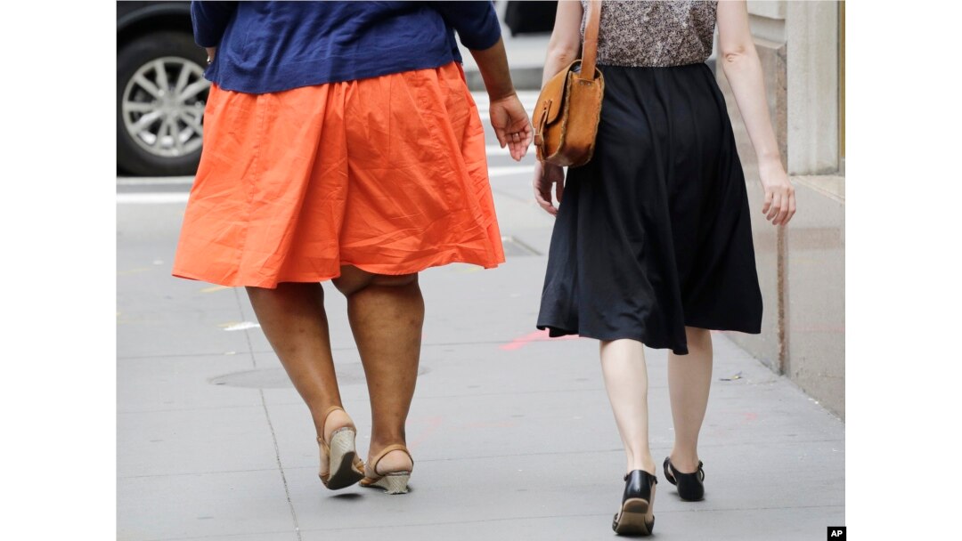 Seorang perempuan dengan masalah berat badan berlebih berjalan di New York, 13 Juli 2015. (Foto: dok)