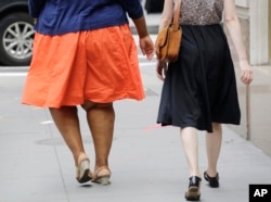 Seorang perempuan dengan masalah berat badan berlebih berjalan di New York, 13 Juli 2015. (Foto: dok)