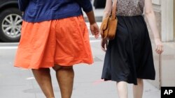 FILE - Two people walk down a street in New York, July 13, 2015. A new study in mice shows that obese mice had fewer taste buds than lean mice.