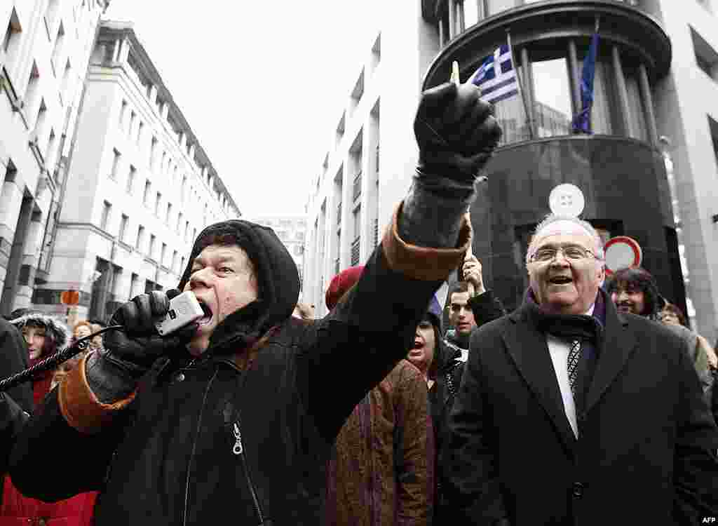 Một người hô khẩu hiệu trong cuộc biểu tình trước đại sứ quán Hy Lạp tại Bruxelles, Bỉ. Bên phải là ông Dimitri Argyropoulos, Chủ tịch cộng đồng người Hy Lạp tại Bỉ, 18 tháng 2, 2012. (Reuters)