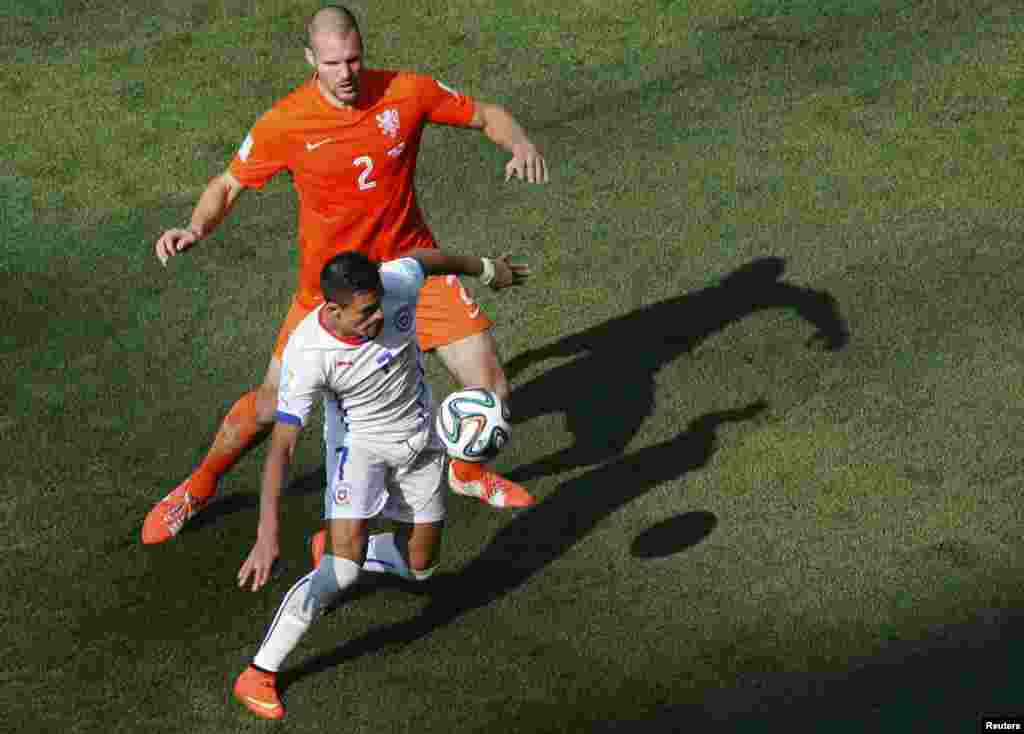 Chile's Alexis Sanchez fights for the ball with Ron Vlaar of the Netherlands during their match at the Corinthians arena in Sao Paulo, June 23, 2014.