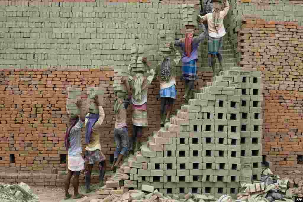 Indian laborers carry clay bricks to a brick kiln in Farakka, in the Indian state of West Bengal, April 3, 2019.