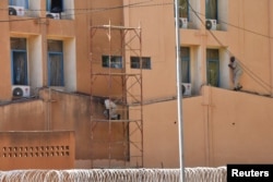 Men escape from Burkina Faso's army headquarters during an attack in the capital, Ougadougou, Burkina Faso, March 2, 2018.