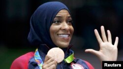 FILE - Fencer Ibtihaj Muhammad of the United States displays her bronze medal at the Rio Olympics in Rio de Janeiro, Brazil, Aug. 13, 2016.