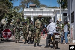 Senegalese soldiers check a motorcyclist at the entrance of the State House compound in Banjul, Gambia, Jan. 24, 2017. ECOWAS troops have moved into the State House to prepare for the return of President Adama Barrow.
