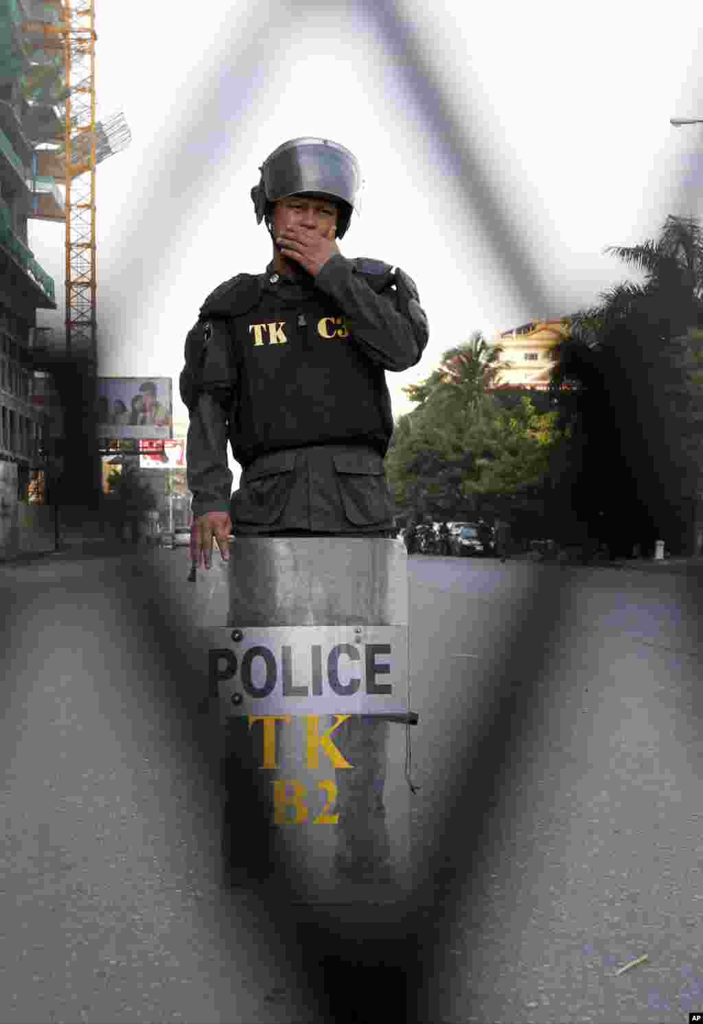 A riot police officer stands guard near Phnom Penh Municipality Court in Phnom Penh, Cambodia, May 30, 2014.
