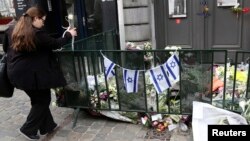 A passer-by places flowers at the entrance of the Jewish Museum in Brussels, Belgium, May 27, 2014.