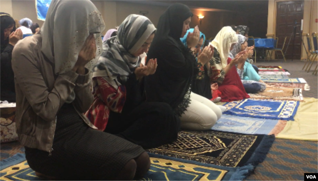 Perempuan Muslim Uighur melakukan sholat Ied di Falls Church, Virginia, 21 Agustus 2018. (B. Gallo/VOA)