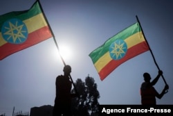 New military recruits who are joining the Ethiopian National Defense Force hold Ethiopian national flags during the send-off ceremony in Addis Ababa, Nov. 24, 2021.