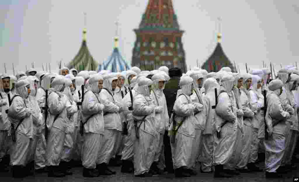 Russian soldiers wear snow gear over Red Army World War II uniforms as they prepare to parade in Red Square in front of St. Basil Cathedral in Moscow, Russia. Thousands of soldiers and military cadets marched across Red Square to mark the 72nd anniversary of a historic World War II parade. The show honored the participants of the Nov. 7, 1941 parade who headed directly to the front lines to defend Moscow from the Nazi forces.