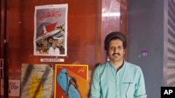 In this Aug. 25, 2017 photo, Saudi filmmaker Ali Kalthami stands next to the poster for his film "Wasati" or "Moderate" and two other Saudi short films recently shown at Cinema Akil in Dubai, United Arab Emirates.