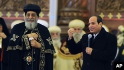 Egyptian President Abdel-Fattah el-Sissi, right, speaks to Coptic Christians as Coptic Pope Tawadros II looks on, during old calendar Christmas Eve Mass at the new Cathedral of the Nativity of Christ, outside Cairo, Egypt, Jan. 6, 2019. 