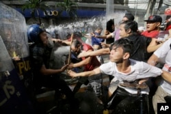 Protesters scuffle with police as they are dispersed while trying to get near the U.S. Embassy in Manila, Philippines to protest against the visit of U.S. President Donald Trump on Nov. 12, 2017.