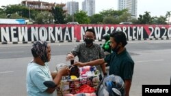 Para pelanggan mengenakan masker wajah membeli kopi di jalan di tengah pandemi virus corona (Covid-19), Jakarta, 19 Agustus 2020. (Foto: Reuters)