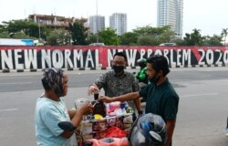 Para pelanggan mengenakan masker wajah membeli kopi di jalan di tengah pandemi virus corona (Covid-19), Jakarta, 19 Agustus 2020. (Foto: Reuters)