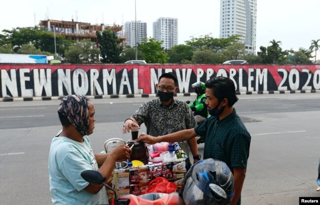 Para pelanggan mengenakan masker wajah membeli kopi di jalan di tengah pandemi virus corona (Covid-19), Jakarta, 19 Agustus 2020. (Foto: Reuters)