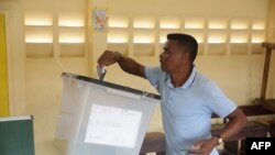 Un électeur dépose son bulletin dans l’urne dans une bureau de vote à Libreville, le 27 octobre 2018., 