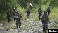 Sejumlah tentara Indonesia berpatroli di perbatasan Provinsi Papua dan Papua Nugini, 17 Maret 2016. (Foto: Antara Foto via Reuters)