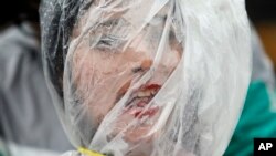 A Nepalese activist stands wrapped in a plastic sheet with a rope tied around her neck as a mark of protest against air pollution on Earth Day in Kathmandu, Nepal.