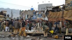 Polisi dan warga berdatangan di lokasi, pasca ledakan bom di pasar Quetta, Pakistan hari Kamis (10/1). 