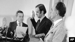 FILE - Four-year-old Beau Biden, foreground, plays near his father, Joe Biden, center, as he is sworn in as the U.S. senator from Delaware, by Senate Secretary Frank Valeo, left, in ceremonies in a Wilmington hospital, Jan. 5, 1973. Beau was injured in an