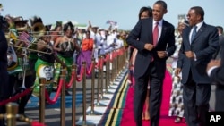 President Barack Obama, followed by first lady Michelle Obama, does a dance upon his arrival ceremony with Tanzanian President Jakaya Kikwete, right, July 1, 2013, at Julius Nyerere International Airport in Dar Es Salaam, Tanzania.