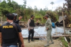 Polisi memeriksa bangunan yang dibakar dalam serangan kelompok teroris Mujahidin Indonesia Timur (MIT) pimpinan Ali Kalora di Dusun Lewonu, Desa Lemban Tongoa, Kecamatan Palolo, Kabupaten Sigi, Sulawesi Tengah, Sabtu (28/11/2020). (Foto: Courtesy/Humas Po