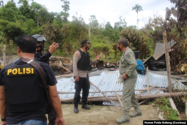 Polisi memeriksa bangunan yang dibakar dalam serangan kelompok teroris Mujahidin Indonesia Timur (MIT) pimpinan Ali Kalora di Dusun Lewonu, Desa Lemban Tongoa, Kecamatan Palolo, Kabupaten Sigi, Sulawesi Tengah, Sabtu (28/11/2020). (Foto: Courtesy/Humas Po