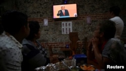 Clients watch leftist front-runner Andres Manuel Lopez Obrador, of the National Regeneration Movement (MORENA), on TV during the transmission of the first presidential debate at a restaurant in Mexico City, April 22, 2018. 