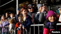 Spectators react as they watch the 95th Macy's Thanksgiving Day Parade in Manhattan, New York City, Nov. 25, 2021.