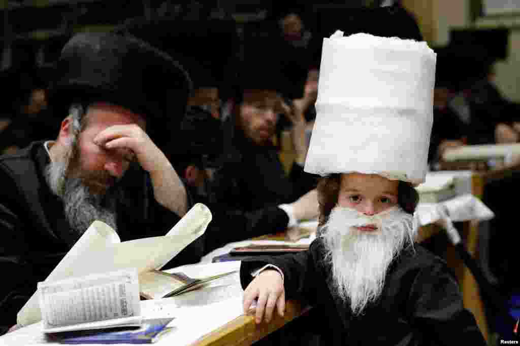 초정통파 유대교인들이 부림절을 맞아&nbsp;이스라엘 서부 아시도드 유대교 회당에서 에스더서를 읽고 있다. &nbsp; 