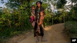 A Rohingya Muslim woman Zahida Banoo holds her son Mohammad Noor, left, and daughter Shah Heer as she poses for a photograph on the way to her shelter in Kutupalong refugee camp, Bangladesh, Friday, Sept. 15, 2017. Those packed into camps and makeshift settlements in Bangladesh are becoming desperate for scant basic resources as hunger and illness soared.