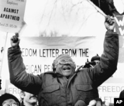 FILE - South African Bishop Desmond Tutu waves during a speech against apartheid, to a crowd of demonstrators, on Jan. 8, 1986, outside the South African Embassy in Washington.