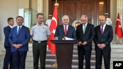 Turkey's Prime Minister Binali Yildirim, center, Chief of Staff Gen. Hulusi Akar, center left, Justice Minister Bekir Bozdag, left, Interior Minister Efkan Ala, second right, and Defense Minister Fikri Isik attend a press conference in Ankara, July 16, 2016.