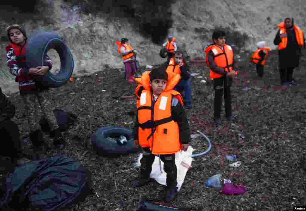 Para anak migran mengenakan pelampung, menunggu perahu yang akan membawa mereka ke Pulau Lesbos, Yunani dari kota Dikili, Turki.