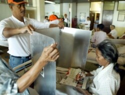 Seorang pasien dibantu petugas untuk melaksanakan hak pilihnya saat pemilu di sebuah rumah sakit di Jakarta, 5 Juli 2004. (Foto: Reuters/arsip))