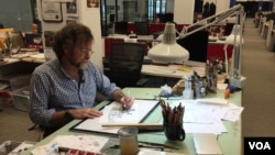 미국 정치 전문 신문 ‘폴리티코(Politico)'의 만평가 매트 워커씨가 사무실 책상에 앉아 만화를 그리고 있다. 