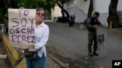 Una mujer sostiene un cartel en apoyo al abatido exoficial de policía Óscar Pérez a la entrada de la morgue en Caracas, el 17 de enero de 2018.