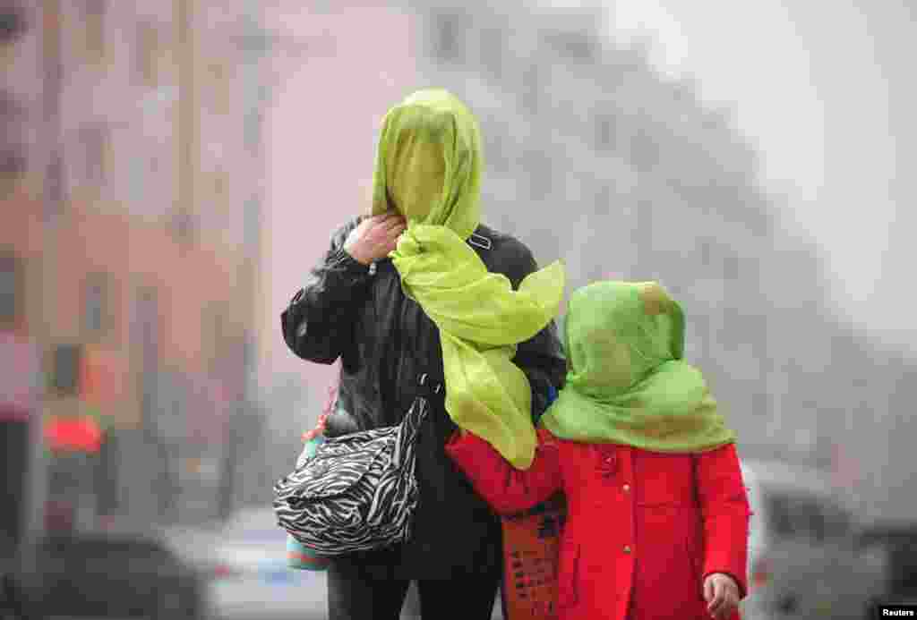 آلودگی هوا و مادر و فرزندی که مجبور به بیرون قدم زدن هستند. چین.