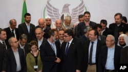 Syrian opposition chairman Sheikh Mouaz Al-Khatib (center, left) chats with the Coalition’s newly elected interim prime minister, Ghassan Hitto (center right).