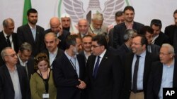 Syrian opposition chairman Sheikh Moaz Al-Khatib (left) congratulates the Coalition’s newly elected interim prime minister, Ghassan Hitto (right), as other coalition members look on at the end of a long one-day election Monday night in Istanbul (AP)