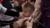 During a mobile health and nutrition team visit in Nasaji village, a nutrition nurse measures arm circumference of a child to determine their nutritional status in Nasaji village in Kandahar province, Afghanistan.