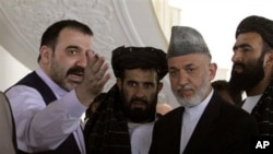 Afghan President Hamid Karzai, second from right, is met by his half brother Ahmad Wali Karzai, left, in Argandab district of Kandahar province, south of Kabul, 09 Oct 2010