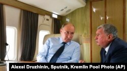 资料照：俄罗斯总统普京与俄罗斯石油公司(ROSN.MM)总裁伊戈尔·谢钦(Igor Sechin) 在飞机上交谈。（2018年8月27日）