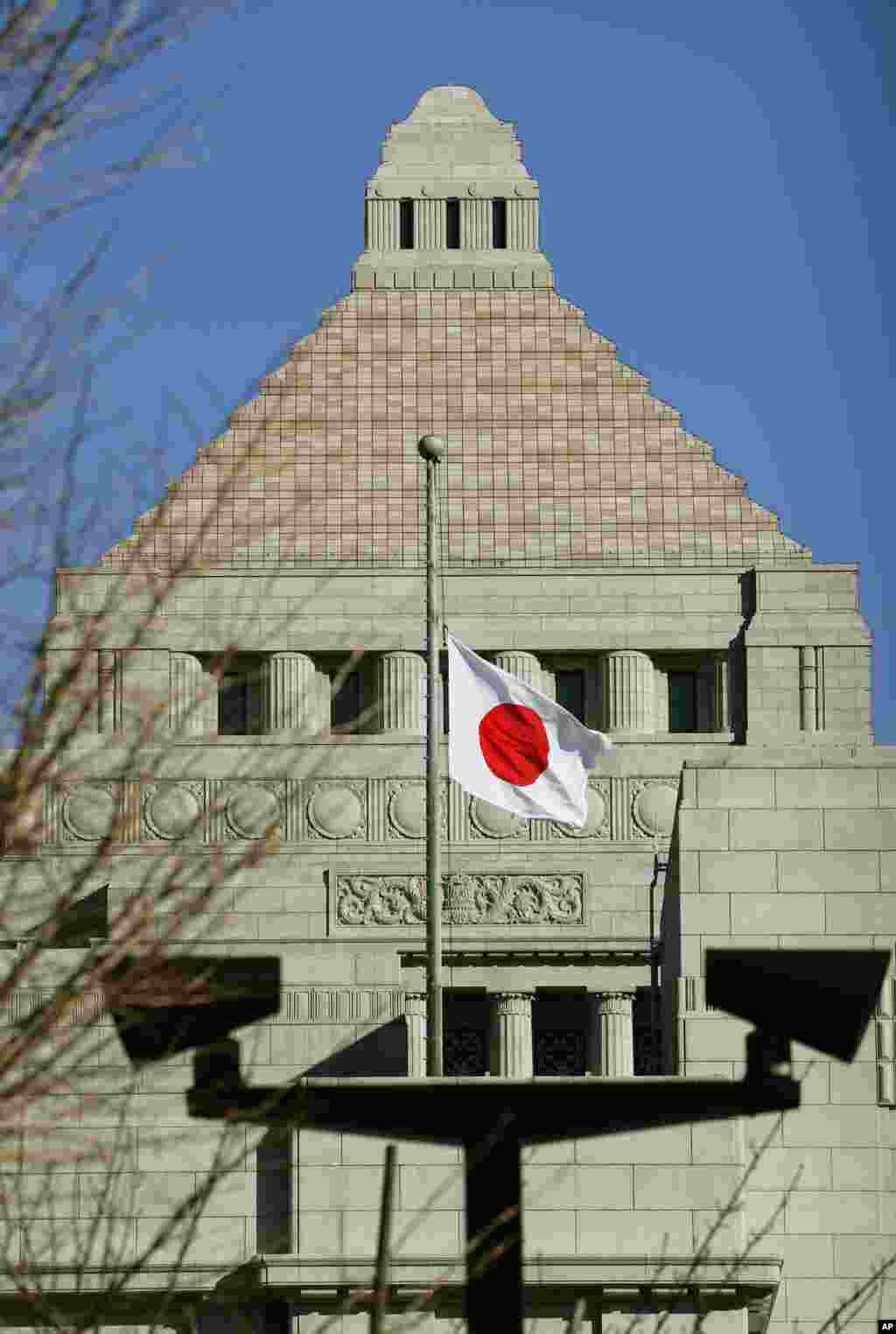 Bendera nasional Jepang dikibarkan setengah tiang sebagai bentuk duka cita untuk para korban gempa dan tsunami 11 Maret 2011, di gedung Parlemen di Tokyo (11/3). (AP/Kyodo News)&nbsp;