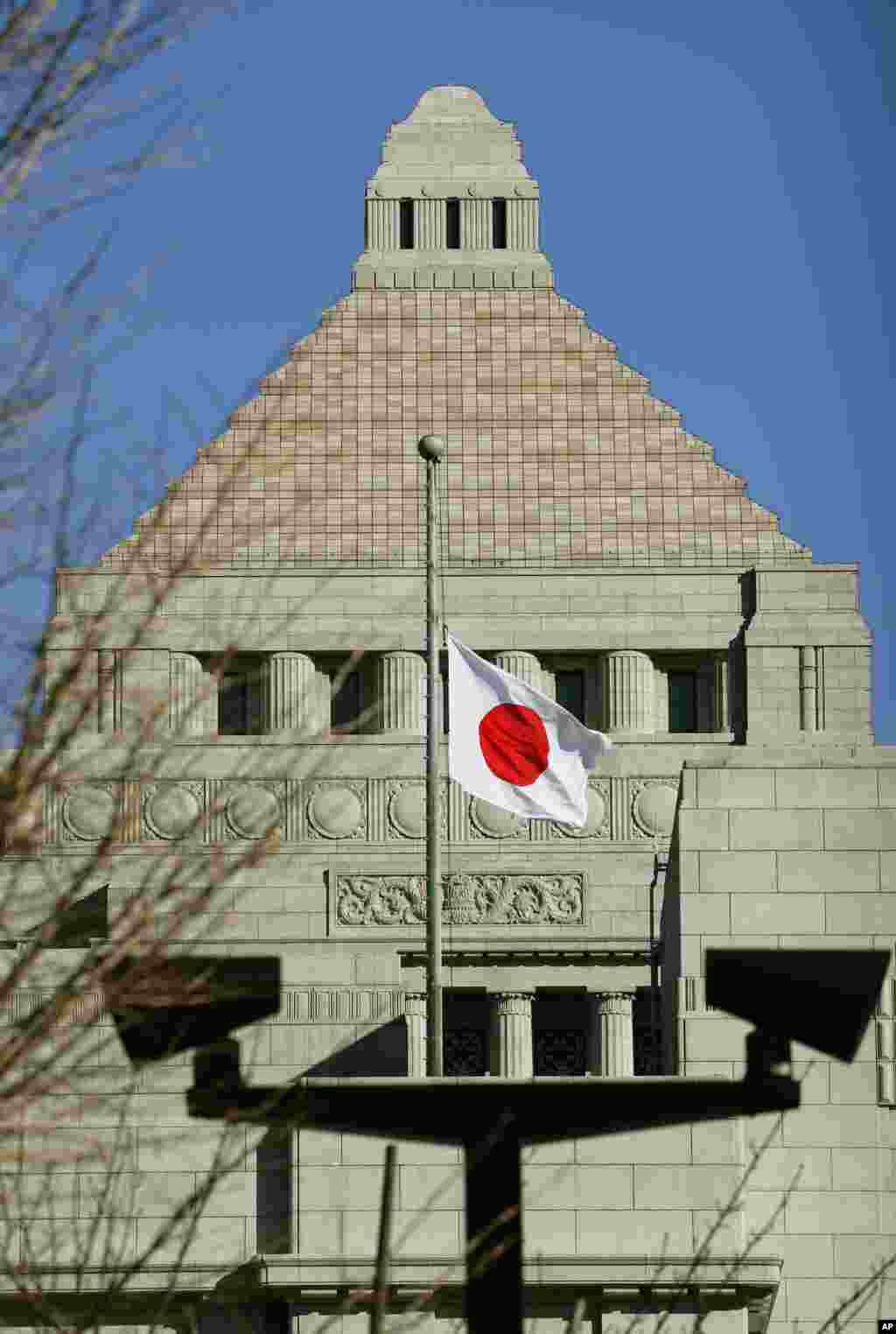 Japan's national flag flies at half-mast to mourn victims of the March 11, 2011 earthquake and tsunami, at the Parliament building in Tokyo, March 11, 2015.