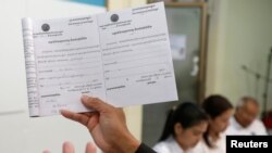 Thành viên của Ủy ban bầu cử quốc gia Campuchia và người phát ngôn Dim Sovannarom đưa ra danh sách các đảng đã đăng ký tranh cử tại Phnom Penh, ngày 30/4/2018. 