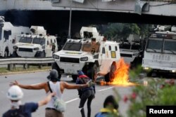 An armored riot police vehicle is seen on fire during a rally against Venezuela's President Nicolas Maduro in Caracas, Venezuela May 1, 2017.