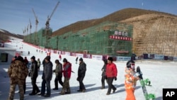 河北省一座滑雪场上的民工、滑雪者和正在建造的滑雪公寓。如果北京获得冬奥主办权，部分比赛将在这里举行（2014年12月6日）