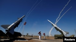 FILE - Missiles are launched at the International Army Games 2017 at the Ashuluk shooting range outside Astrakhan, Russia, Aug. 5, 2017. The United States says Russia must scrap or modify some of its weapons in order to remain in compliance with a key arms control treaty.